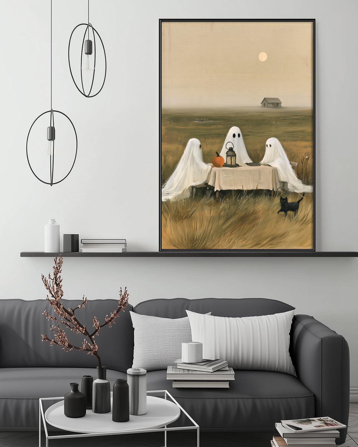 a living room with a gray couch, a coffee table, and a large framed painting depicting three ghostly figures sitting at a table in a field.