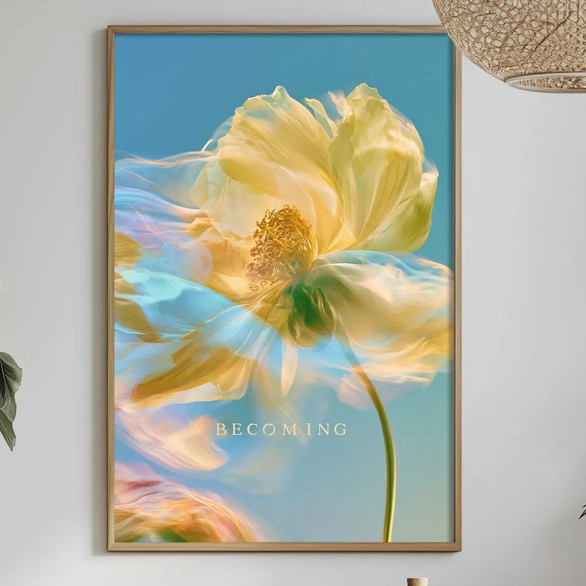a dining table with a white tablecloth, a bowl of fruit, a bottle, and a vase with flowers. Above the table, there is a framed picture of a yellow flower with a blue background.