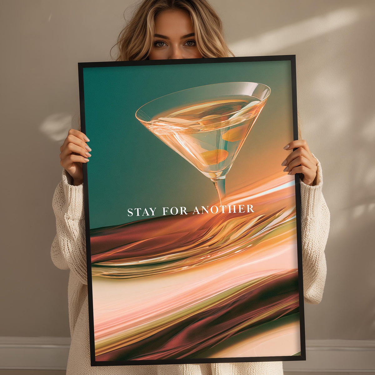 A woman holding a framed poster with a colorful abstract design featuring a martini glass.