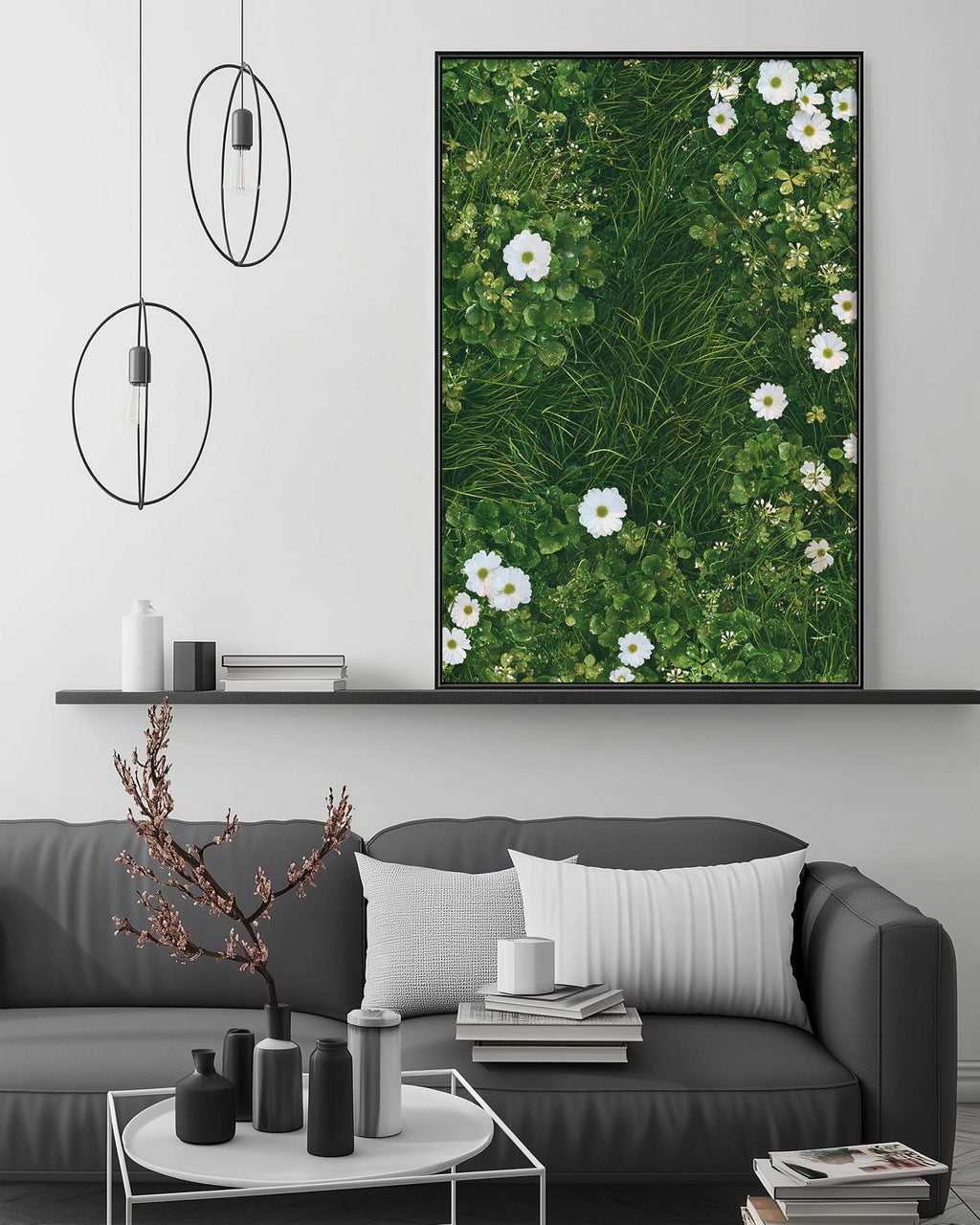 a modern living room with a gray sofa, a coffee table, and a large framed picture of white flowers on the wall above the sofa.