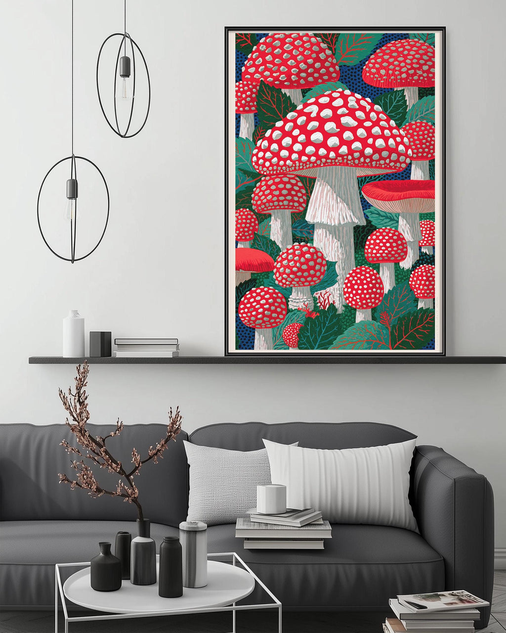 a large framed artwork depicting a whimsical scene of red and white mushrooms growing amidst green leaves and branches, hanging above a gray couch in a cozy living room setting.