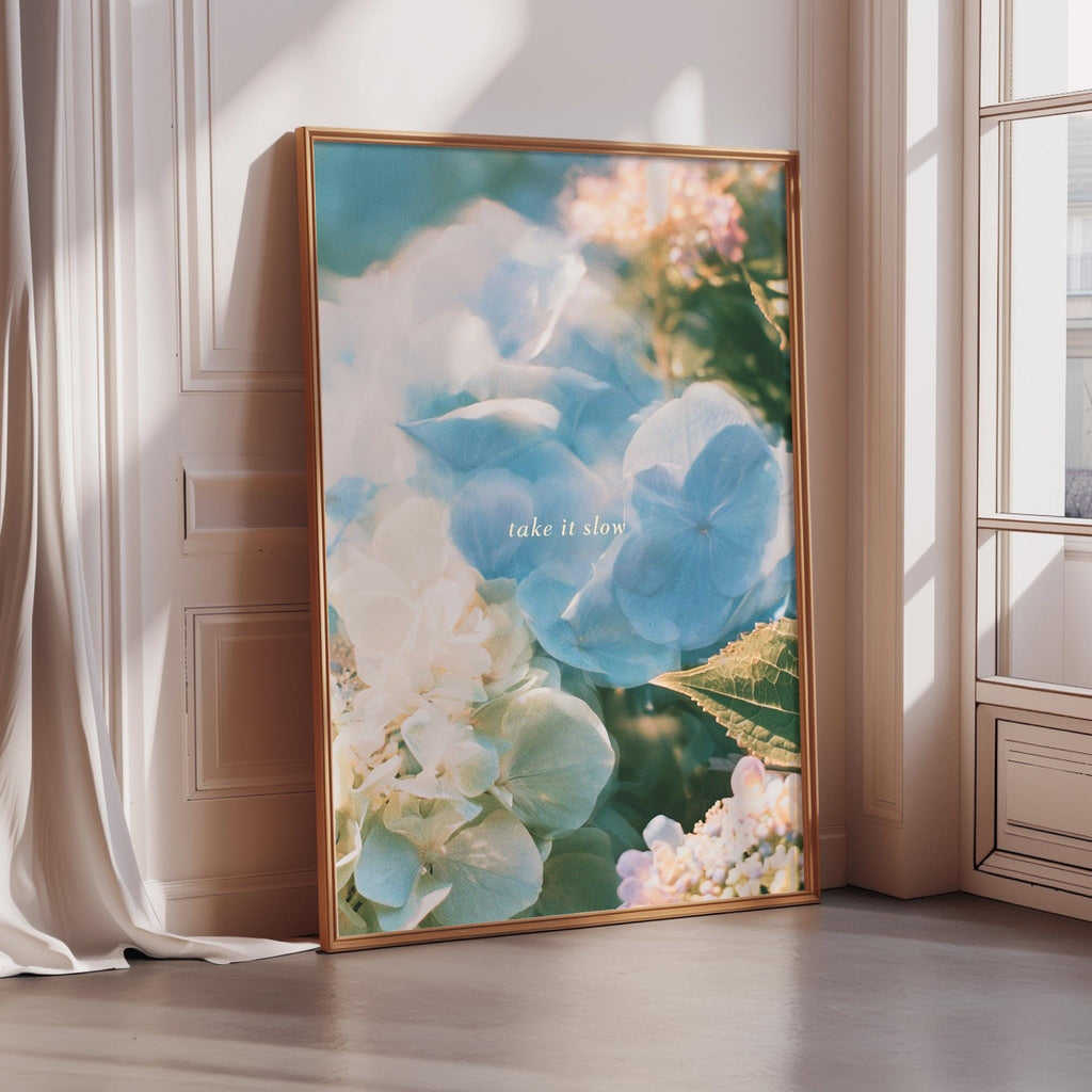 A framed photograph of a vibrant floral arrangement, with the text "Take it slow" overlaid on the image.