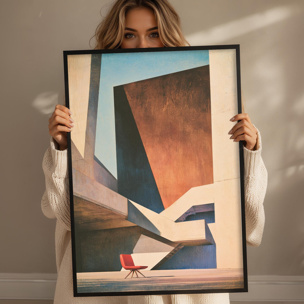 A woman holds up a framed abstract painting depicting a red chair in a minimalist, geometric setting.
