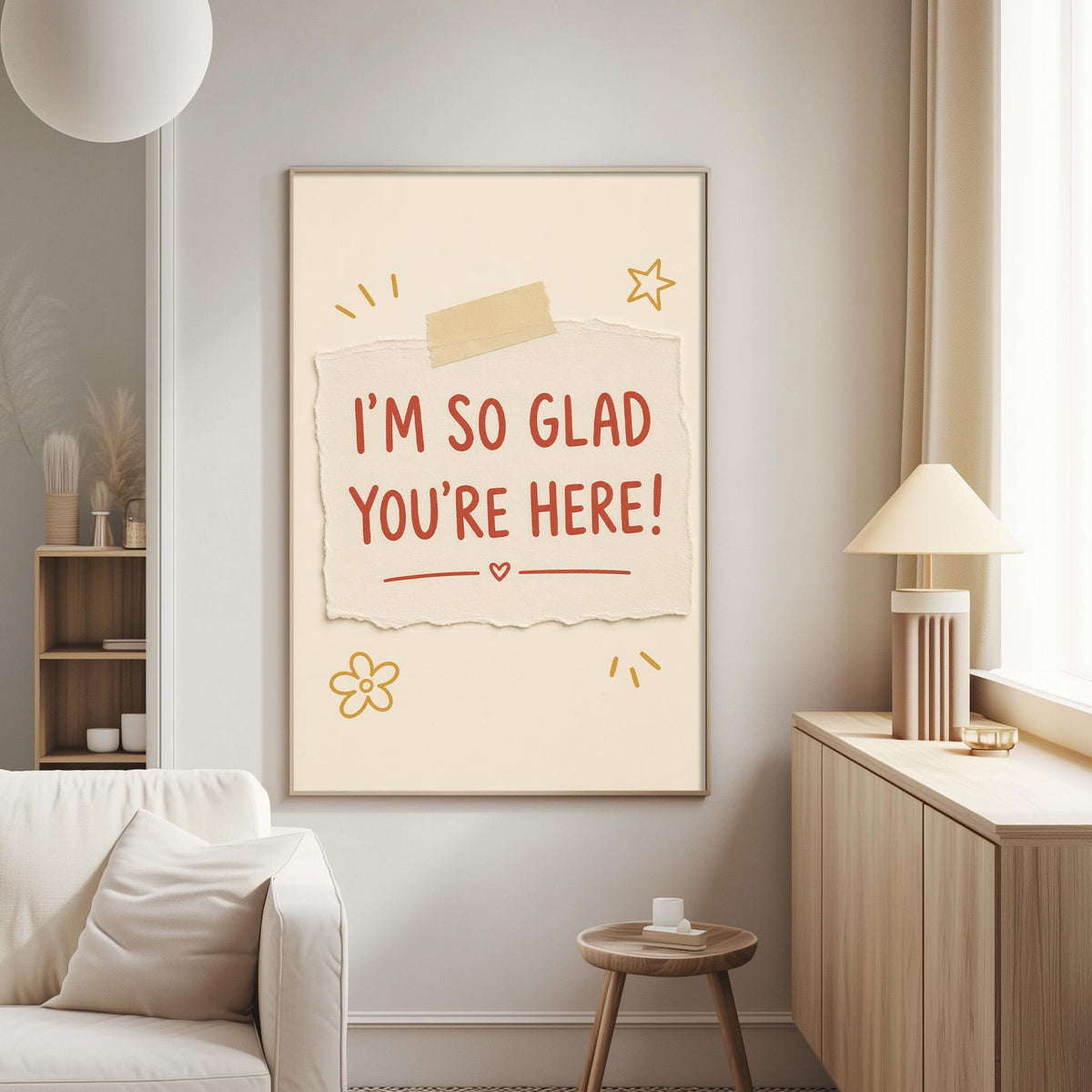 a living room with a white couch, a wooden side table, and a framed poster on the wall. The poster has a message that says "I'm so Glad You're Here!"