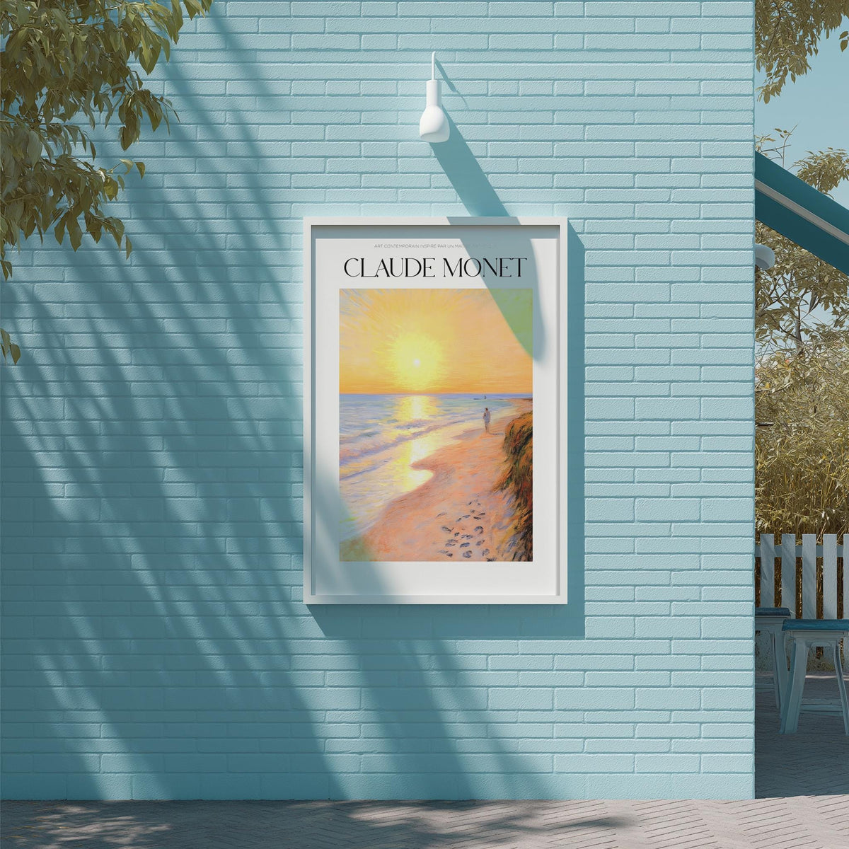 A framed painting of a beach scene hangs on a blue wall, with a tree and a building visible in the background.
