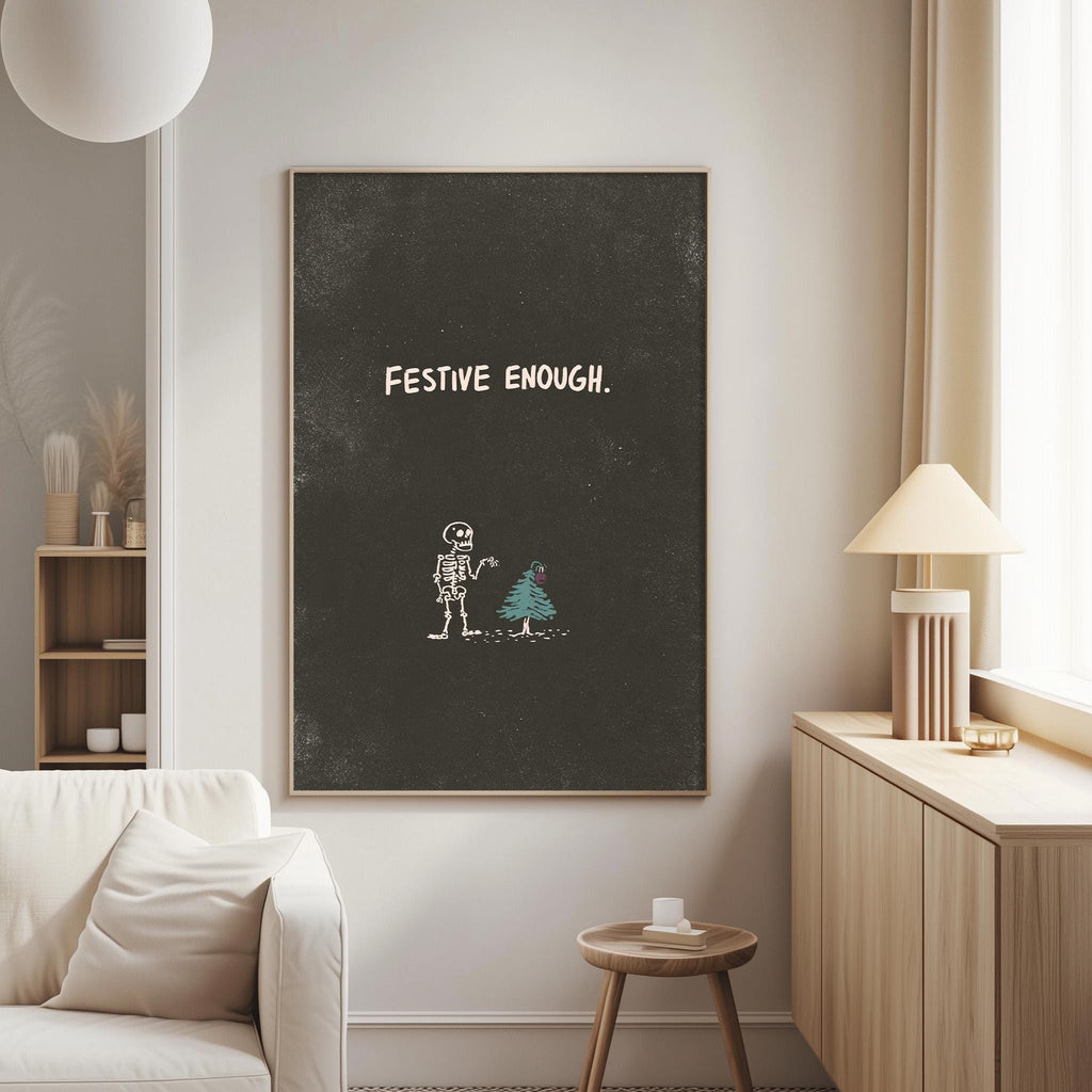 a living room with a white sofa, a wooden side table, and a lamp. Above the sofa, there is a blackboard with the text "FESTIVE ENOUGH" written on it.