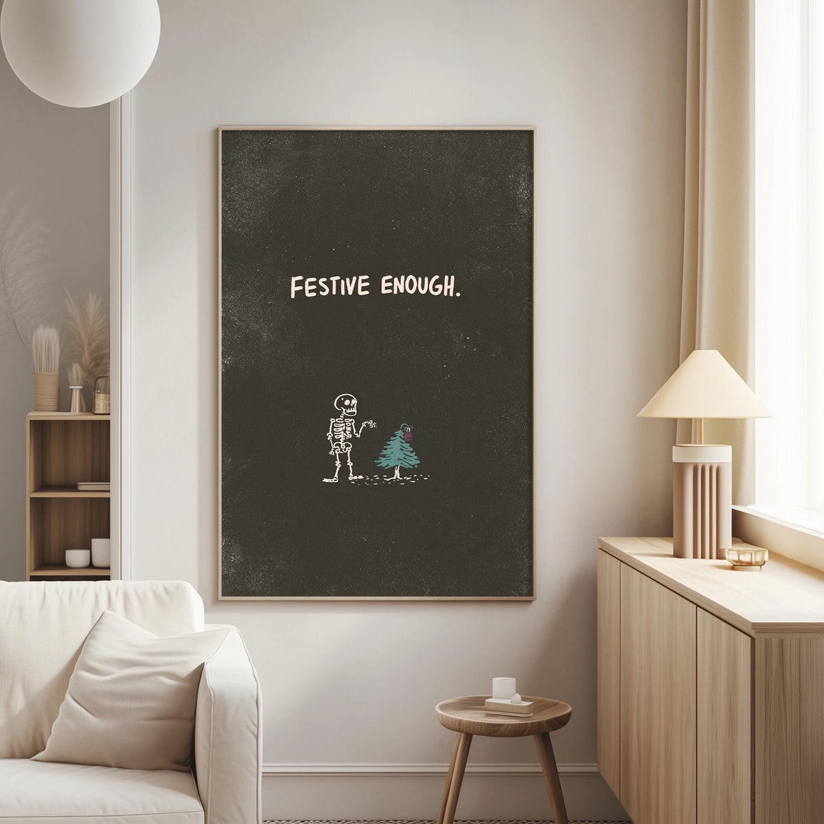 a living room with a white sofa, a wooden side table, and a lamp. Above the sofa, there is a blackboard with the text "FESTIVE ENOUGH" written on it.