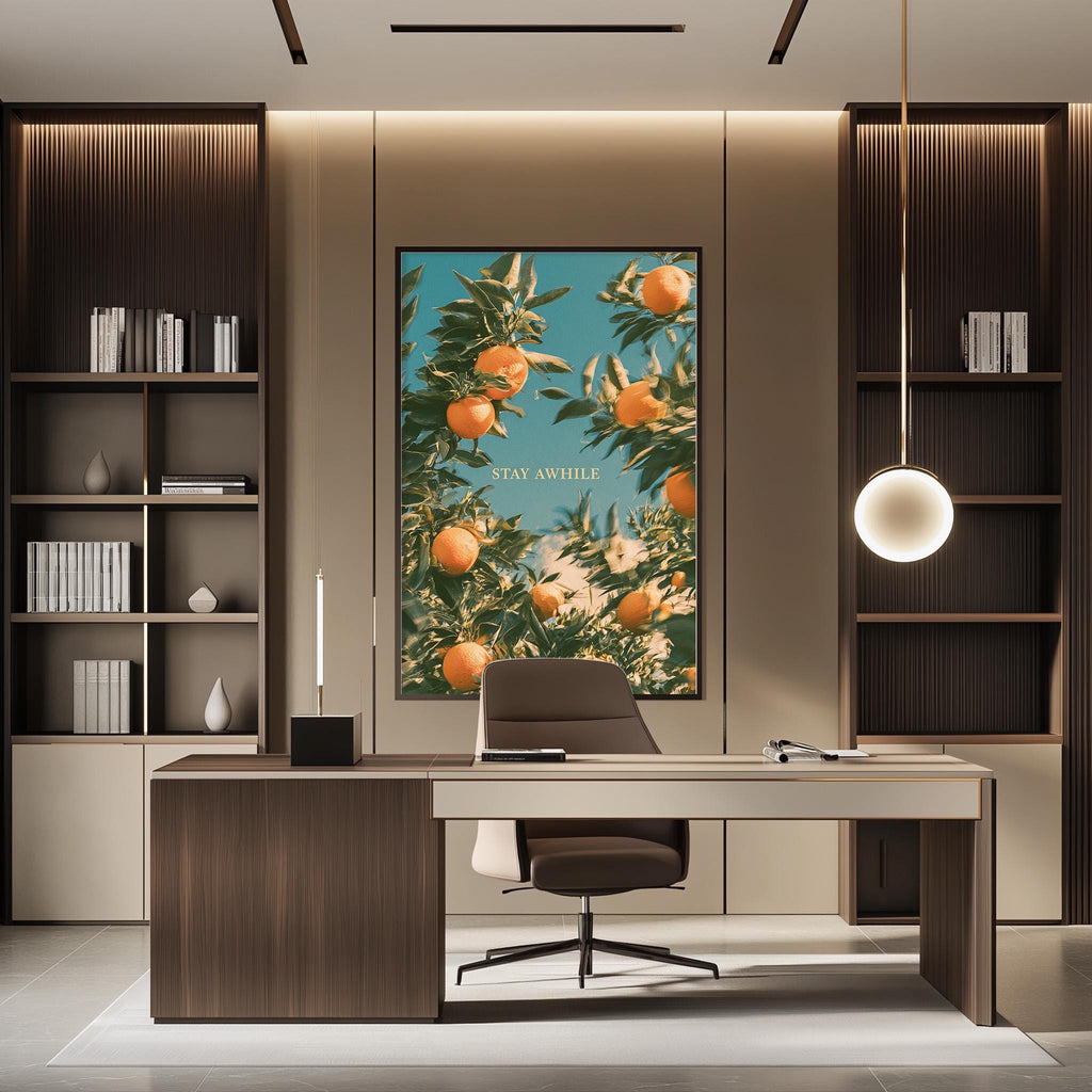 a modern office space with a large framed poster of an orange tree on the wall, a wooden desk with a chair, and built-in bookshelves.