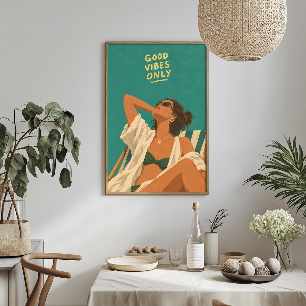 a framed illustration of a woman in a bikini, with the text "GOOD VIBES ONLY" written above her. The setting appears to be a dining area with a table, chairs, and various decorative elements such as potted plants and vases.