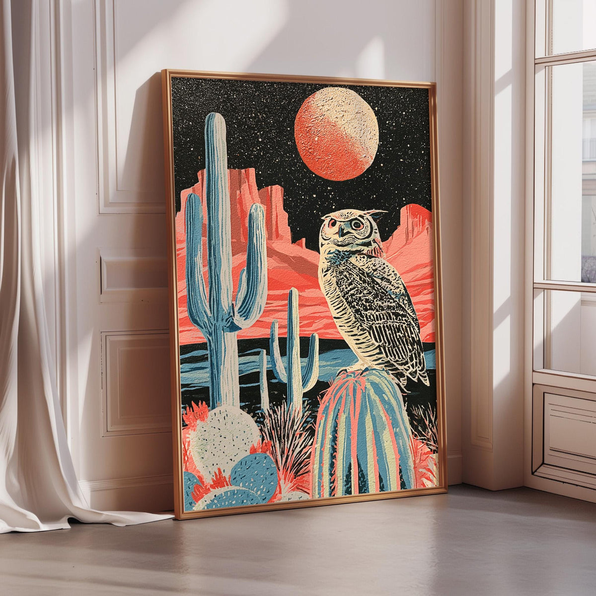 The image is a framed artwork depicting a desert scene with a cactus, a large red moon, and an owl perched on a rock.