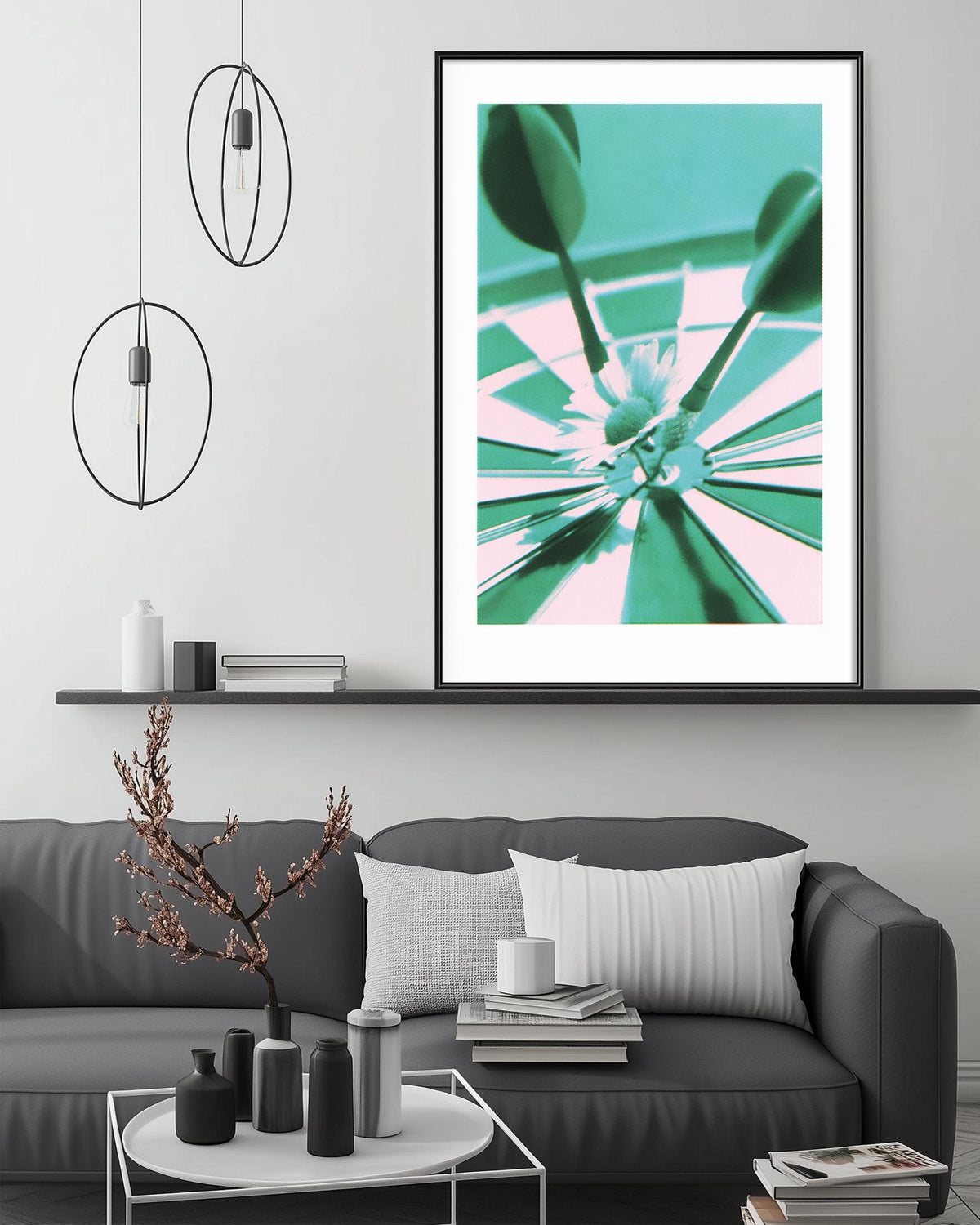 a modern living room with a gray sofa, a coffee table, and a large framed artwork depicting a close-up of a flower and two arrows. The artwork is hanging above a shelf with various decorative items, creating a stylish and contemporary atmosphere.