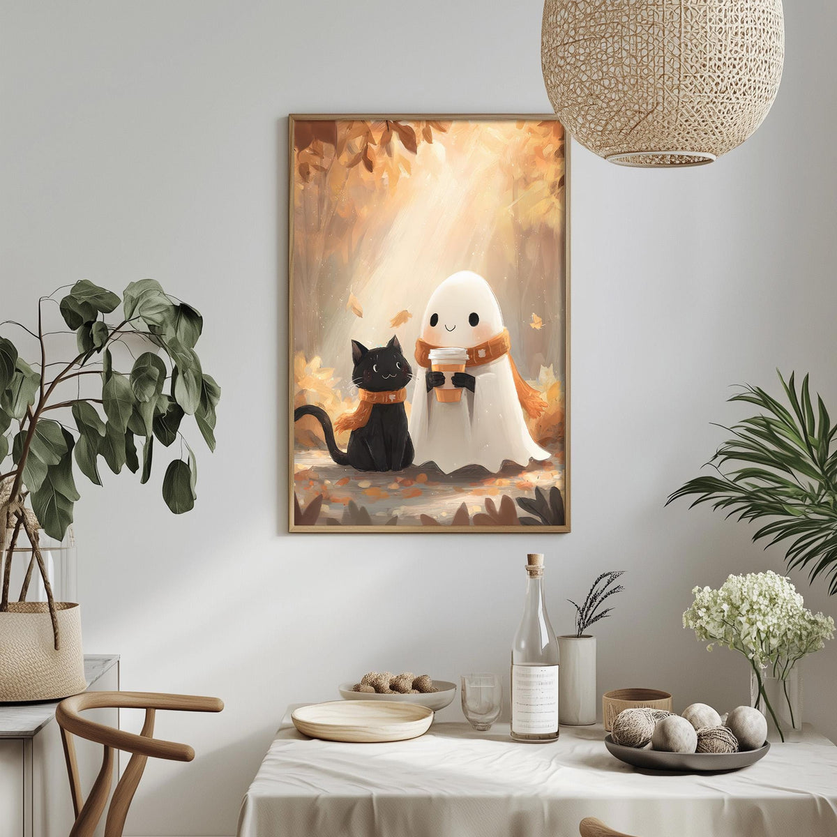 a cozy and whimsical scene with a framed illustration of a ghost and a black cat sitting together on a table. The table is set with various items, including a bottle, a bowl, and a vase, creating a warm and inviting atmosphere. The room is decorated with potted plants and other home decor elements, contributing to the overall charm and comfort of the space.