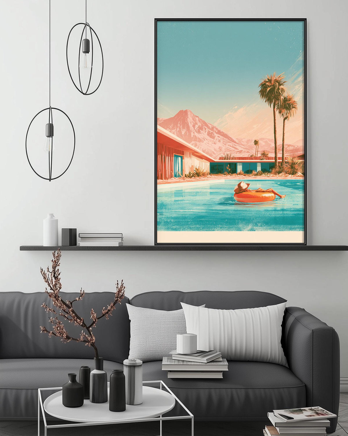a modern living room with a gray sofa, a coffee table, and a large framed poster of a beach scene with palm trees and a swimming pool.