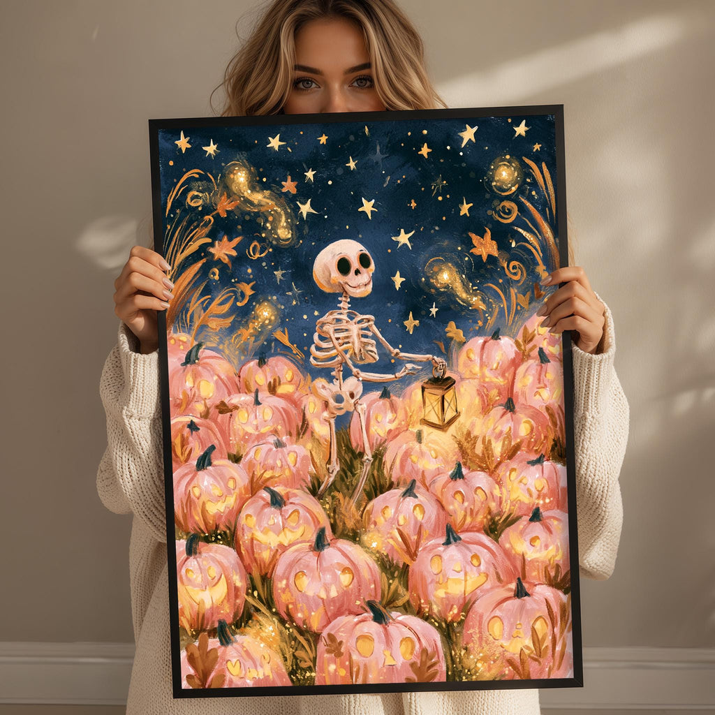 A woman holds up a framed artwork depicting a skeleton standing amidst a field of pumpkins, with a starry night sky in the background.