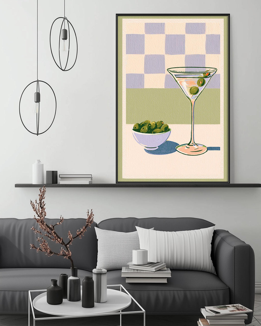 a living room with a gray couch, a coffee table, and a framed illustration of a martini glass with olives on the wall above it.