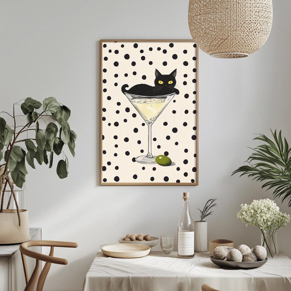 a framed illustration of a cat sitting in a martini glass, surrounded by various decorative elements such as plants, a bowl, and a bottle.