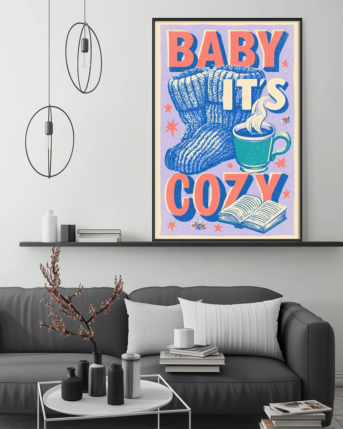 a cozy living room with a gray couch, a coffee table, and a framed poster on the wall that reads "BABY IT'S COZY".