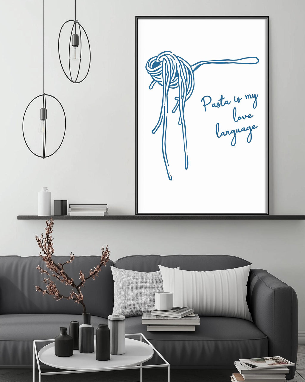 a cozy living room with a gray couch, a coffee table, and a framed poster on the wall. The poster depicts a noodle with the text "Pasta is my love language" written on it.