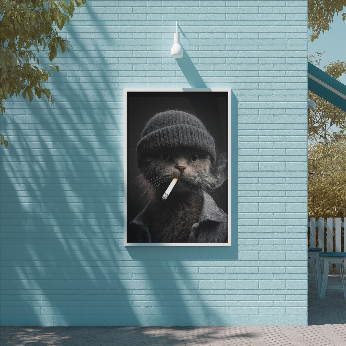 A framed image of a cat wearing a knit hat and smoking a cigarette is displayed on a blue brick wall.