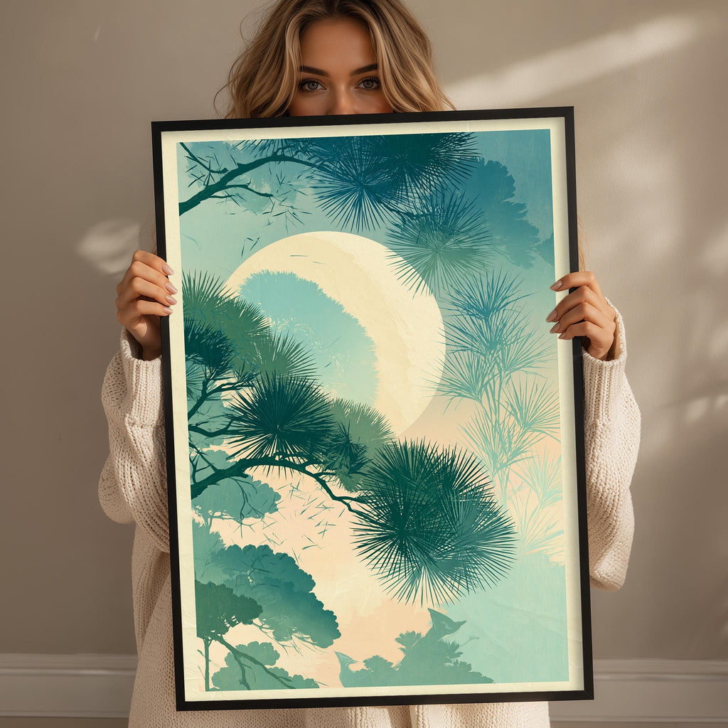 A woman holding a framed print of a tropical landscape with palm trees and a large moon in the sky.