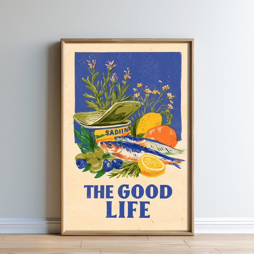The image is a framed poster with a vibrant illustration of various fruits and vegetables, including a can of Sadiolos, a lemon, and an orange. The text "THE GOOD LIFE" is prominently displayed in the bottom of the poster.