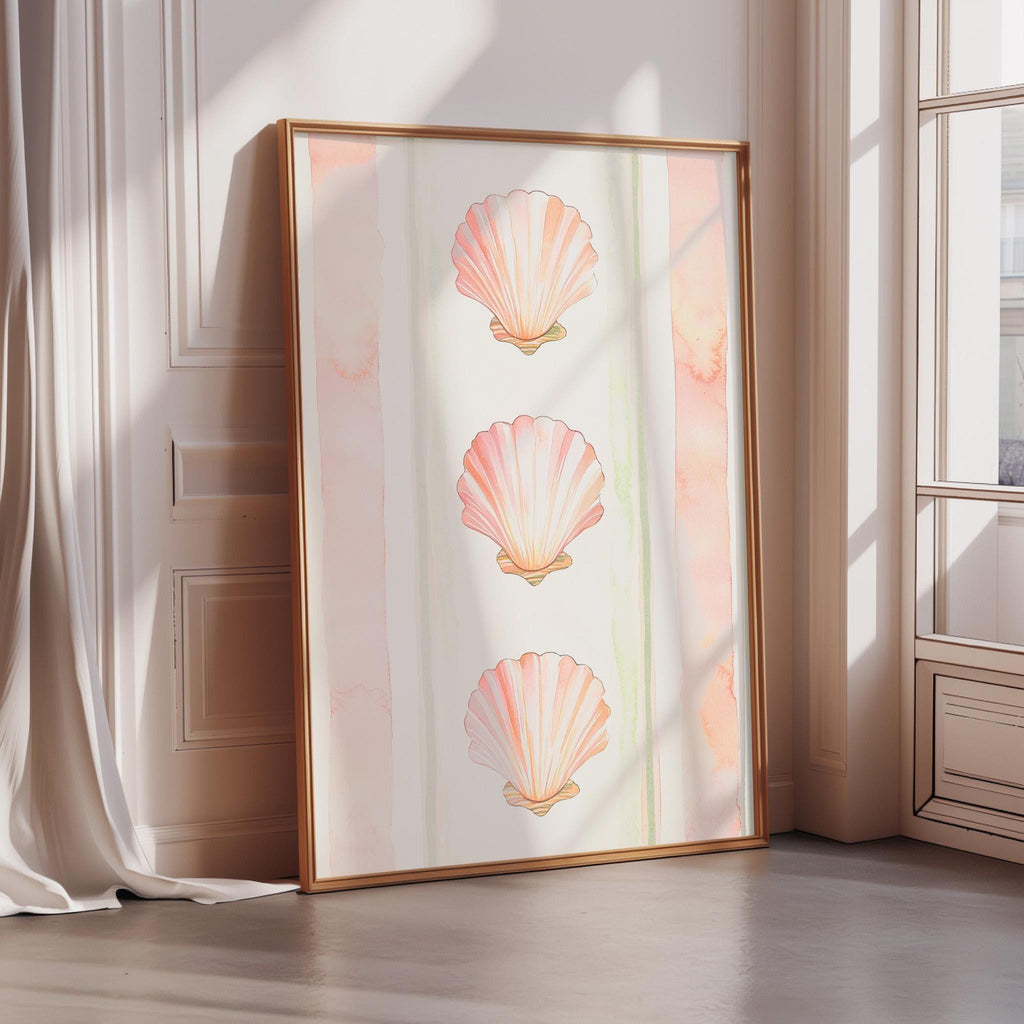 A framed print of three pink seashells is displayed on a wall in a room with a window.
