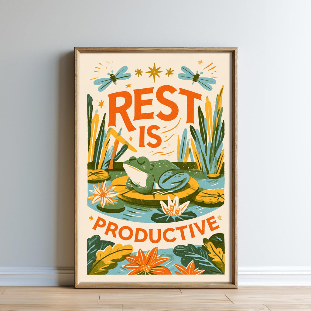 The image is a framed poster with a vibrant illustration of a frog sitting in a pond surrounded by flowers and plants. The text on the poster reads "REST IS PRODUCTIVE" and is surrounded by stars and butterflies.