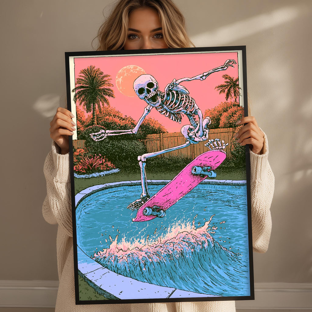 A woman holds up a framed illustration of a skeleton skateboarding on a pink skateboard, with a sunset and palm trees in the background.