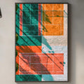 a modern kitchen with a large abstract painting hanging on the wall above a countertop. The painting has a vibrant mix of orange, green, and red colors, creating a lively and energetic atmosphere. The kitchen also includes a potted plant, a cutting board, and various kitchen items such as a sink, a bottle, and a bowl.